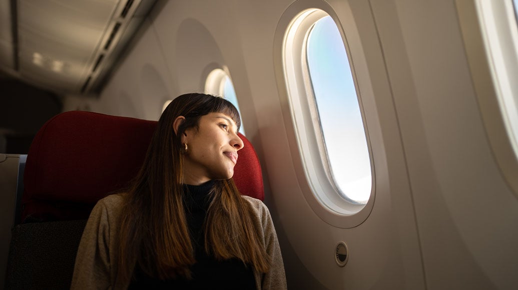 Woman looking out the window of an airplane