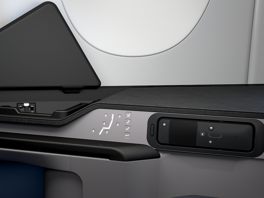 Control panel on an aircraft passenger seat with various adjustment buttons and a compartment for holding a device