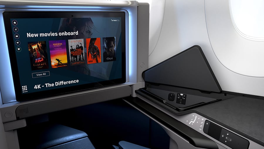 Airplane seat with built-in entertainment screen displaying movie options